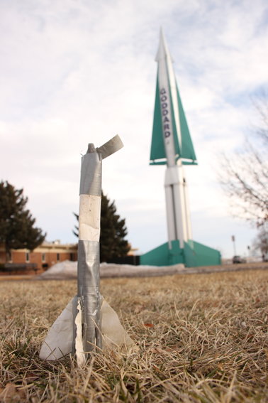 A child's duct-tape rocket sits on the lawn outside Goddard Middle School, backed by the school's historic Nike Hercules missile. The district has decided to get rid of the missile to expand the parking lot, and longtime locals are hoping to find it a new home.